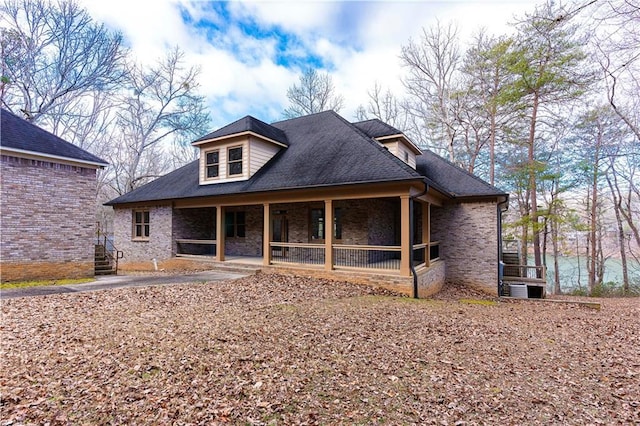 view of front of home featuring a shingled roof, stairs, and brick siding