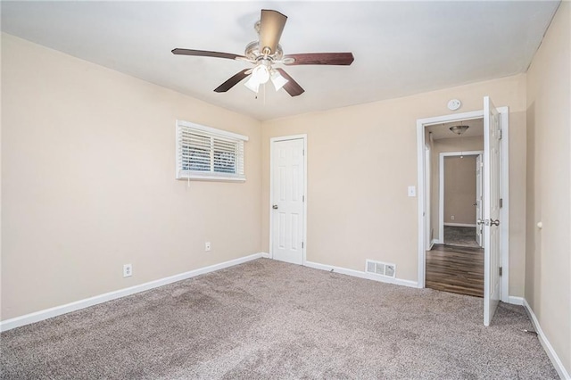 spare room with ceiling fan and carpet