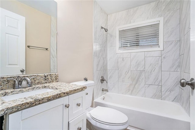 full bathroom featuring tiled shower / bath combo, vanity, and toilet