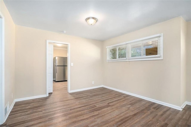 spare room featuring wood-type flooring