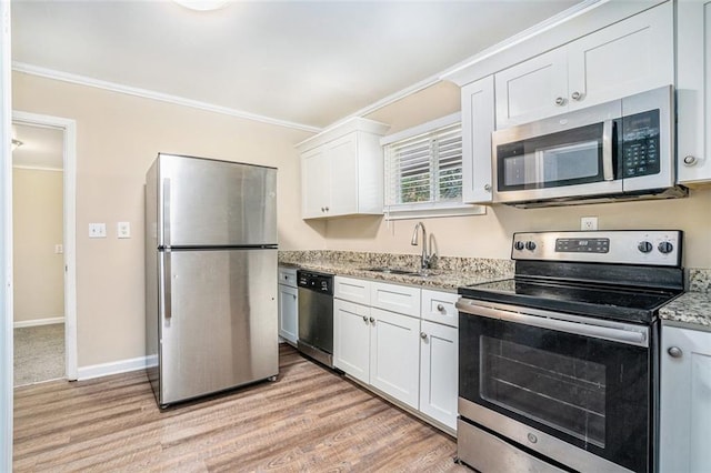 kitchen with crown molding, appliances with stainless steel finishes, light stone countertops, and white cabinets