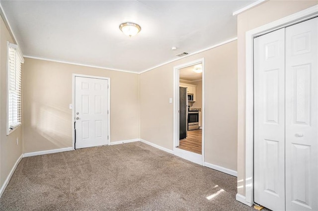 unfurnished room with crown molding and carpet