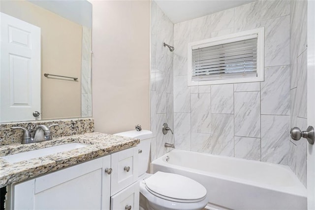 full bathroom featuring vanity, tiled shower / bath, and toilet