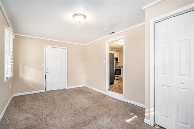 spare room featuring crown molding and carpet