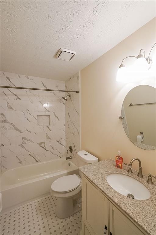 full bathroom featuring vanity, tiled shower / bath, tile patterned flooring, toilet, and a textured ceiling