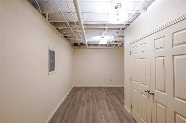 basement with electric panel and hardwood / wood-style floors