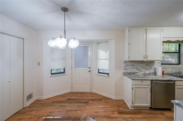 interior space with pendant lighting, light hardwood / wood-style flooring, white cabinetry, and stainless steel dishwasher