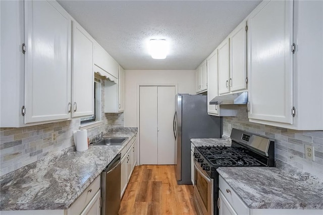 kitchen featuring white cabinetry, sink, appliances with stainless steel finishes, and light hardwood / wood-style flooring