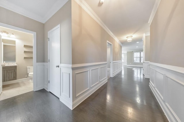 hallway with dark hardwood / wood-style floors and ornamental molding