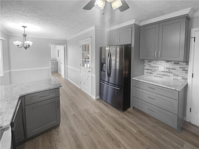 kitchen featuring gray cabinets, decorative light fixtures, stainless steel fridge, and ornamental molding