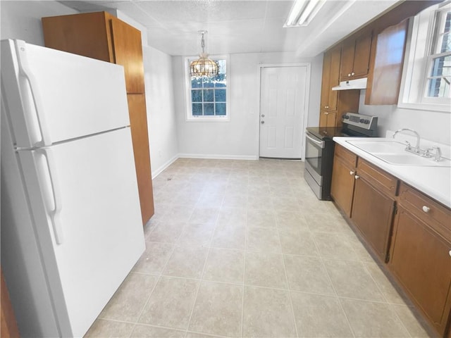 kitchen with sink, electric range, decorative light fixtures, an inviting chandelier, and white fridge