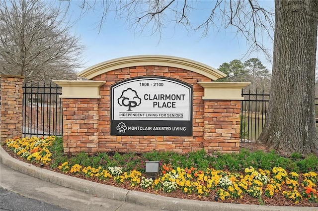 community / neighborhood sign featuring fence