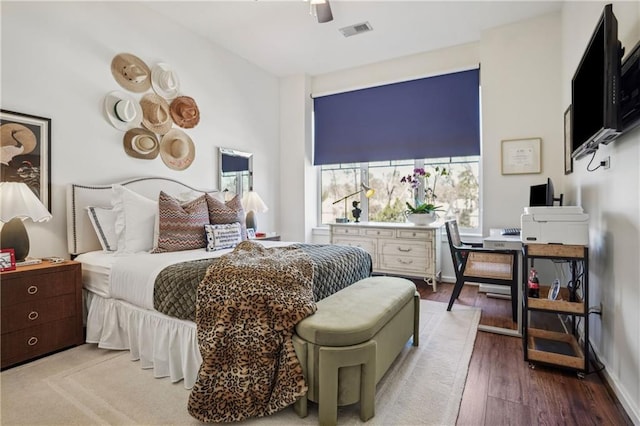 bedroom with visible vents, ceiling fan, baseboards, and wood finished floors