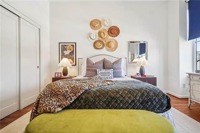 bedroom featuring a closet, baseboards, and wood finished floors