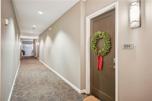 corridor featuring stone finish floor, recessed lighting, and baseboards