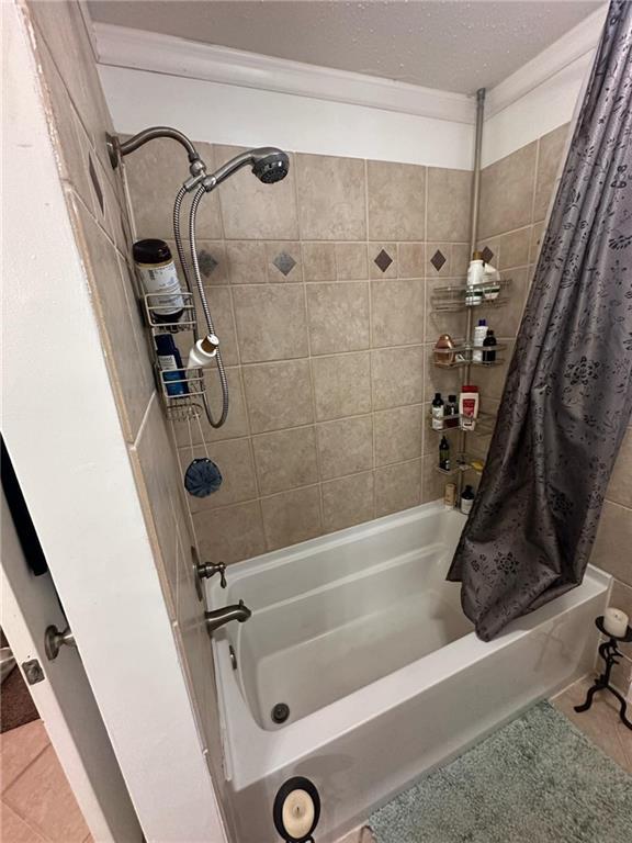 bathroom featuring shower / bathtub combination with curtain and tile patterned floors