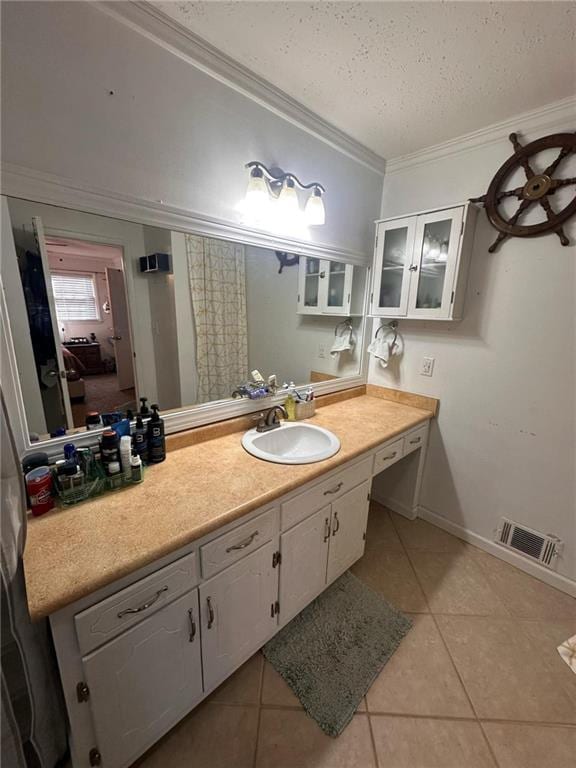 bathroom featuring tile patterned flooring, vanity, crown molding, and a textured ceiling