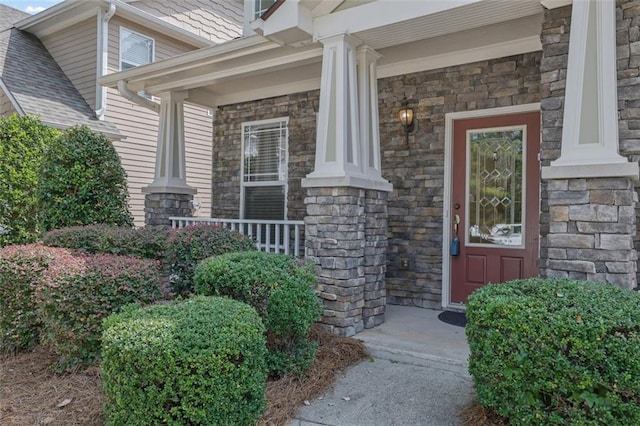 view of exterior entry featuring covered porch