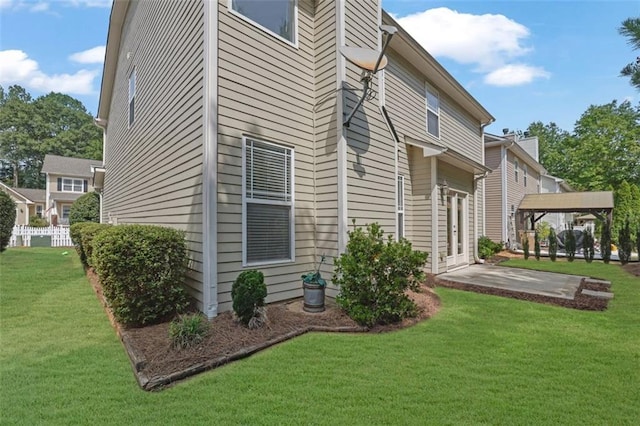 back of house with a patio and a lawn