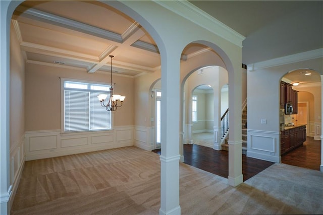 interior space with crown molding, beamed ceiling, coffered ceiling, and a notable chandelier