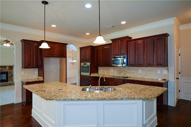 kitchen featuring ceiling fan, sink, stainless steel appliances, and an island with sink