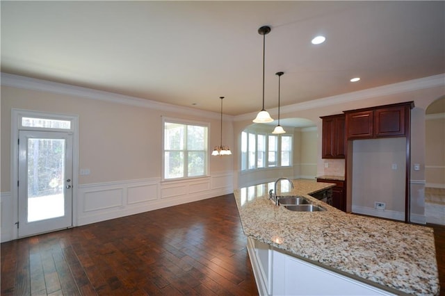 kitchen with a notable chandelier, dark hardwood / wood-style flooring, ornamental molding, and sink