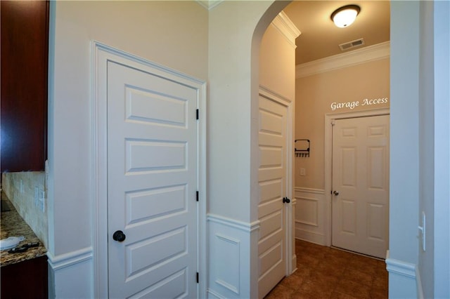 corridor with crown molding and dark tile patterned floors