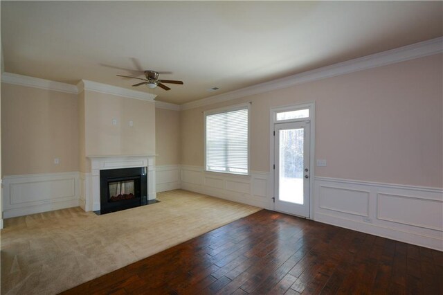 unfurnished living room with hardwood / wood-style floors, ceiling fan, and ornamental molding