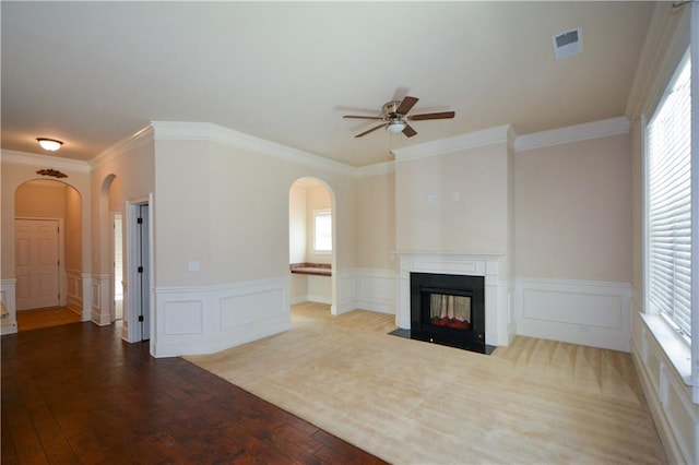 unfurnished living room featuring a multi sided fireplace, light hardwood / wood-style floors, plenty of natural light, and ornamental molding