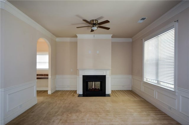 unfurnished living room with a multi sided fireplace, light carpet, and crown molding