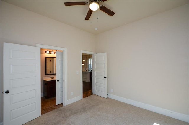 unfurnished bedroom with ceiling fan, light carpet, and ensuite bath