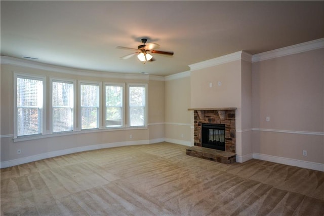 unfurnished living room with crown molding, ceiling fan, a stone fireplace, and light carpet