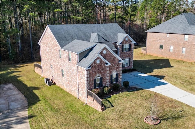 view of front of house featuring central AC unit and a front yard