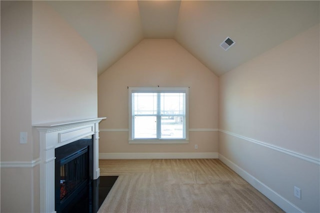 unfurnished living room with light colored carpet and vaulted ceiling