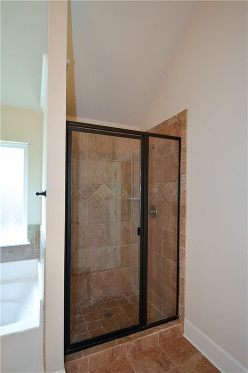 bathroom with tile patterned floors, vaulted ceiling, and independent shower and bath