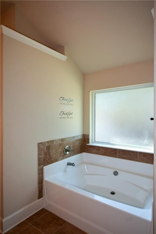 bathroom with tile patterned flooring, vaulted ceiling, and a washtub