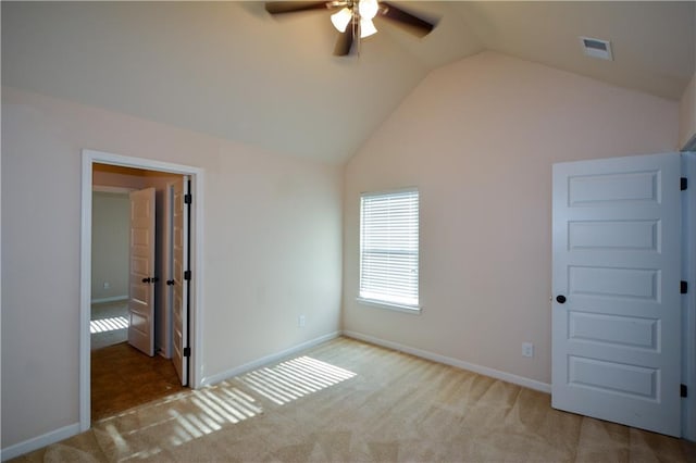 unfurnished bedroom featuring ceiling fan, light colored carpet, and lofted ceiling