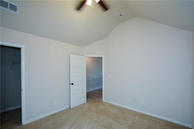 unfurnished bedroom with lofted ceiling, ceiling fan, a spacious closet, light colored carpet, and a closet