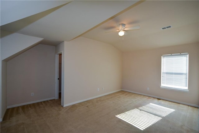 additional living space with light carpet, ceiling fan, and vaulted ceiling