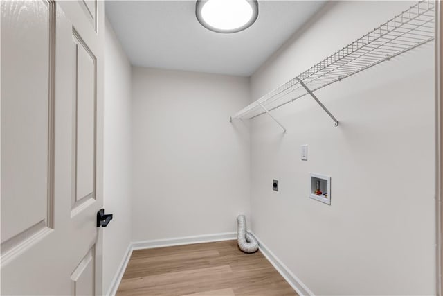 laundry room with laundry area, baseboards, light wood-style flooring, hookup for an electric dryer, and washer hookup