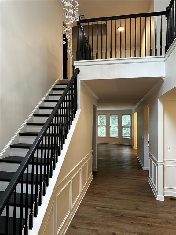 staircase featuring crown molding and hardwood / wood-style floors