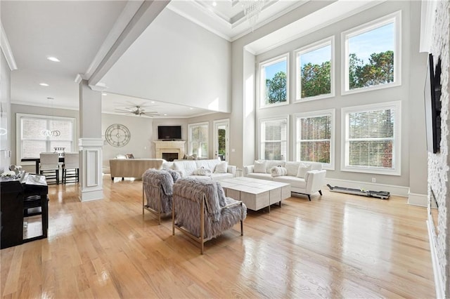 3423 Jamont Blvd, Alpharetta, GA 30022 - living area featuring a fireplace, a high ceiling, a ceiling fan, crown molding, and light wood-type flooring