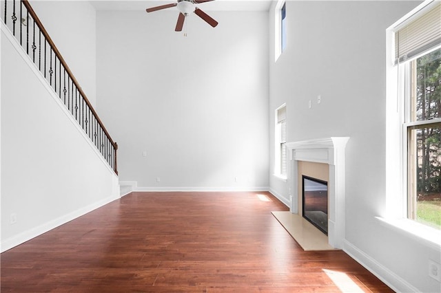 1433 Sand Way, Lawrenceville, GA 30045 - unfurnished living room featuring a high ceiling, plenty of natural light, ceiling fan, a fireplace, and wood finished floors