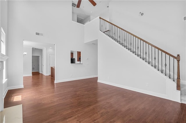 1433 Sand Way, Lawrenceville, GA 30045 - unfurnished living room with a ceiling fan, wood finished floors, a high ceiling, and stairway