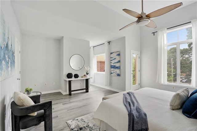 bedroom featuring multiple windows, ceiling fan, and light hardwood / wood-style flooring