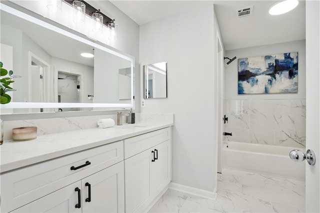 bathroom featuring tiled shower / bath and vanity