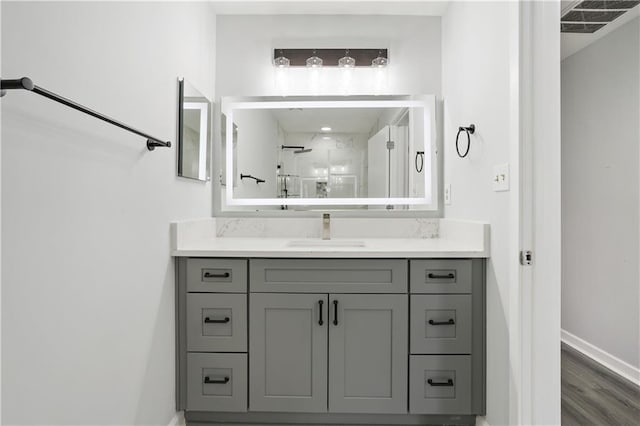 bathroom featuring a shower, hardwood / wood-style floors, and vanity