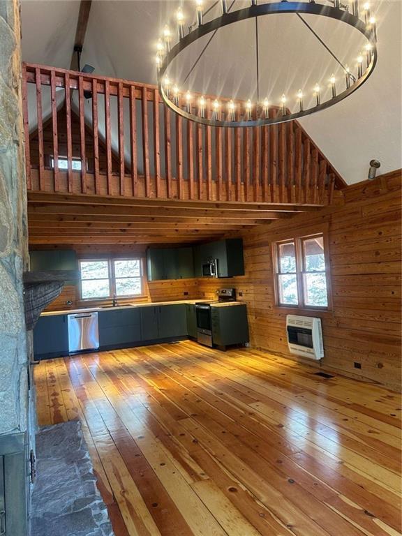 68 Star Lake Ln, Sautee Nacoochee, GA 30571 - kitchen with appliances with stainless steel finishes, a chandelier, hardwood / wood-style floors, heating unit, and wooden walls
