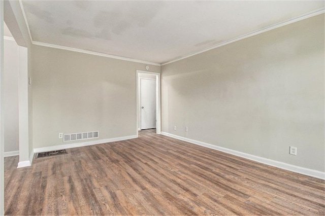 empty room with hardwood / wood-style floors and ornamental molding