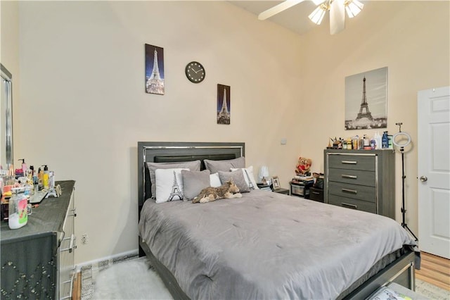 bedroom featuring light hardwood / wood-style flooring, lofted ceiling, and ceiling fan